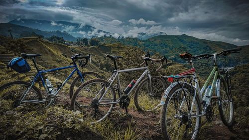 Bicycles on field against sky