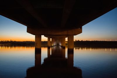 Bridge over river against sky during sunset