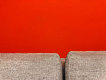 Close-up of sofa against orange wall