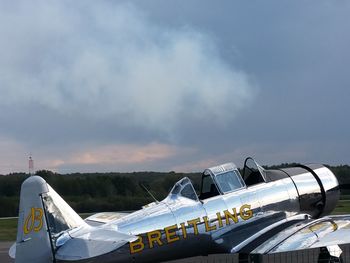 Airplane on airport runway against sky