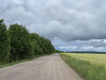 Road amidst field against sky