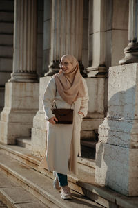 Full length of woman standing against building