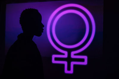 Silhouette of person against illuminated light