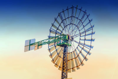 Low angle view of windmill against clear sky during sunset