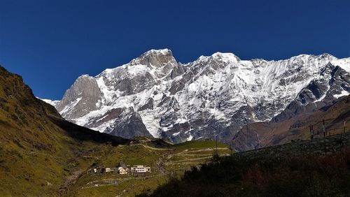 Scenic view of snowcapped mountains against clear blue sky