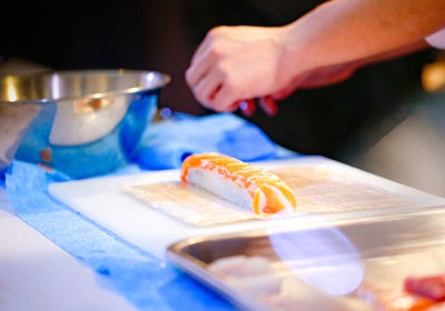 Midsection of person preparing food on cutting board