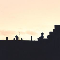 Low angle view of silhouette built structure against sky at sunset