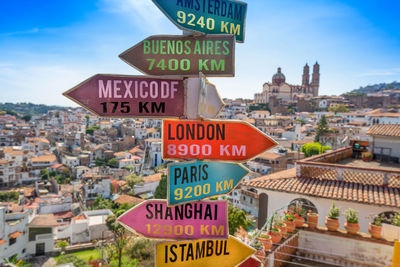 Information sign on townscape against sky