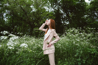 Woman standing by tree on field