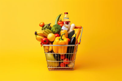 High angle view of small shopping cart against yellow background