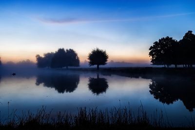 Scenic view of calm lake at sunset