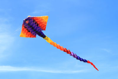 Low angle view of kite flying in blue sky