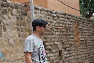 Side view of man standing against wall