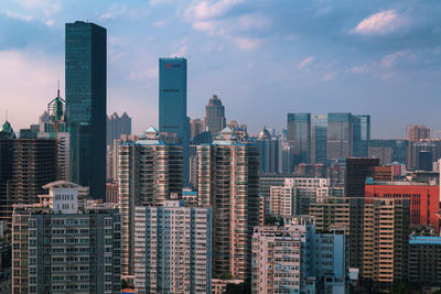 High angle view of skyscrapers against cloudy sky