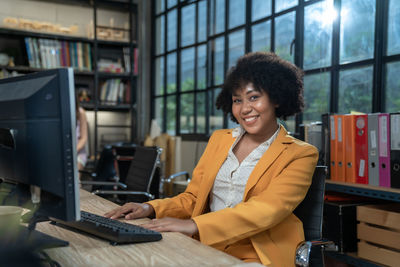 Portrait of young businesswoman working at desk in library