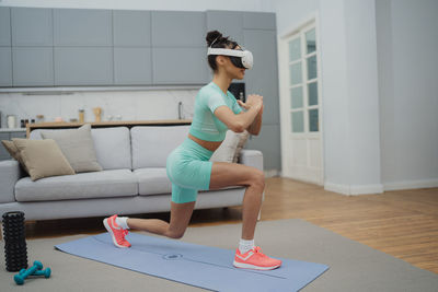Side view of young woman exercising at home