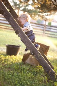 Side view of boy sitting on field