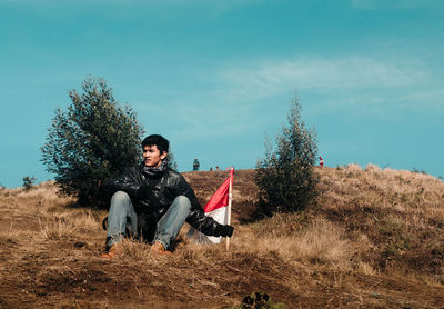 Portrait of young man sitting on field