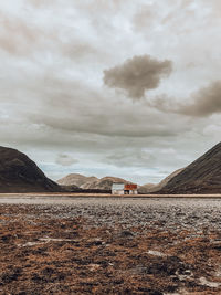 Scenic view of land and houses against sky