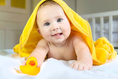 Cute baby girl with towel on head at home