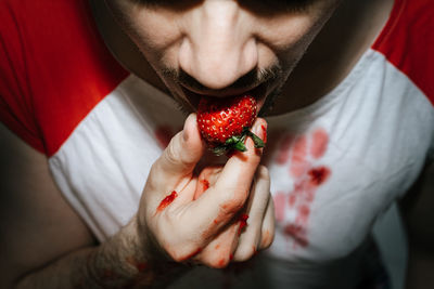 Close-up of man eating strawberry