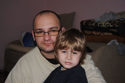 Portrait of father with son sitting at home