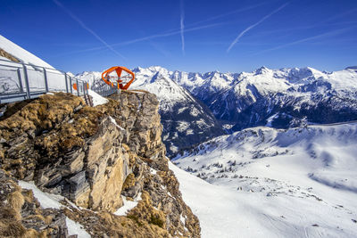 Scenic view of snow covered mountains against blue sky