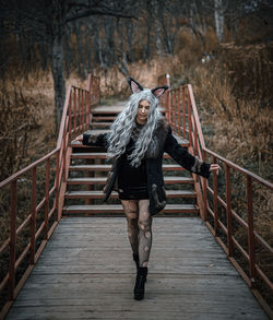 Portrait of man on footbridge in forest