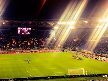 Group of people in illuminated stadium at night