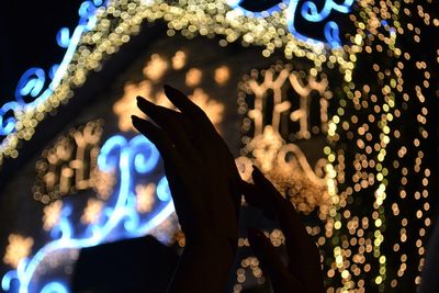 Midsection of person painting illuminated at night