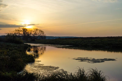 Scenic view of lake against sky during sunset