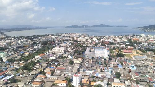 High angle view of townscape by sea against sky