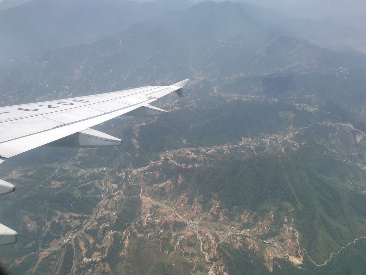 AERIAL VIEW OF MOUNTAINS AND AIRPLANE WING