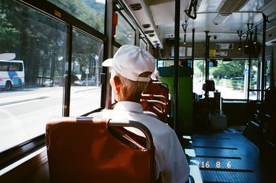 Rear view of man traveling in bus