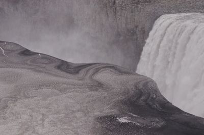 Scenic view of snow covered land and section of waterfall