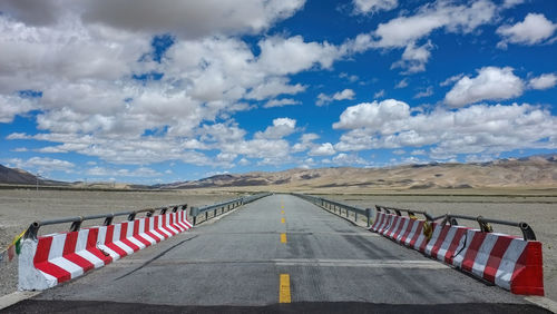 Flat newly built unmanned asphalt road leads to the foot of the distant mountain