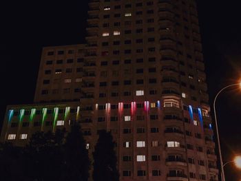 Low angle view of illuminated buildings against sky at night