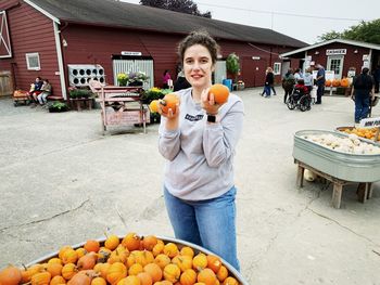 Portrait of smiling young woman holding ice cream outdoors