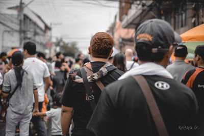 Rear view of people walking on street in city