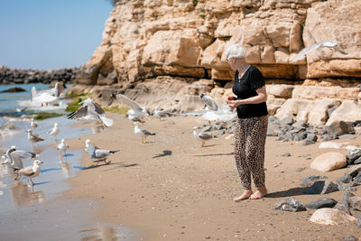 Rear view of woman standing at beach