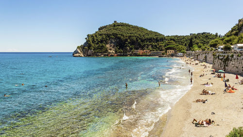 People on beach against clear sky