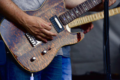 Midsection of man playing guitar