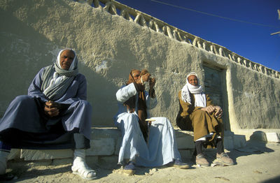 Rear view of people standing against mountain