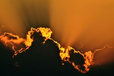 Low angle view of silhouette fire against sky at sunset