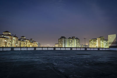 Illuminated buildings against sky at night