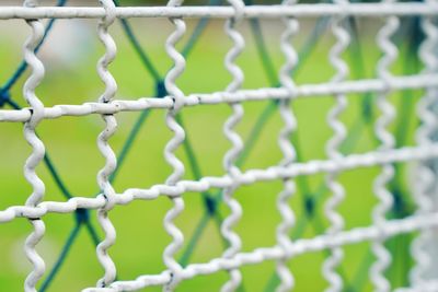 Close-up of metal fence against wall