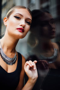 Young woman leaning against black building