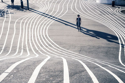 High angle view of woman standing on road in city