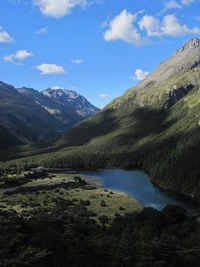 Scenic view of river and mountains against sky