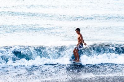 Full length of shirtless man in sea